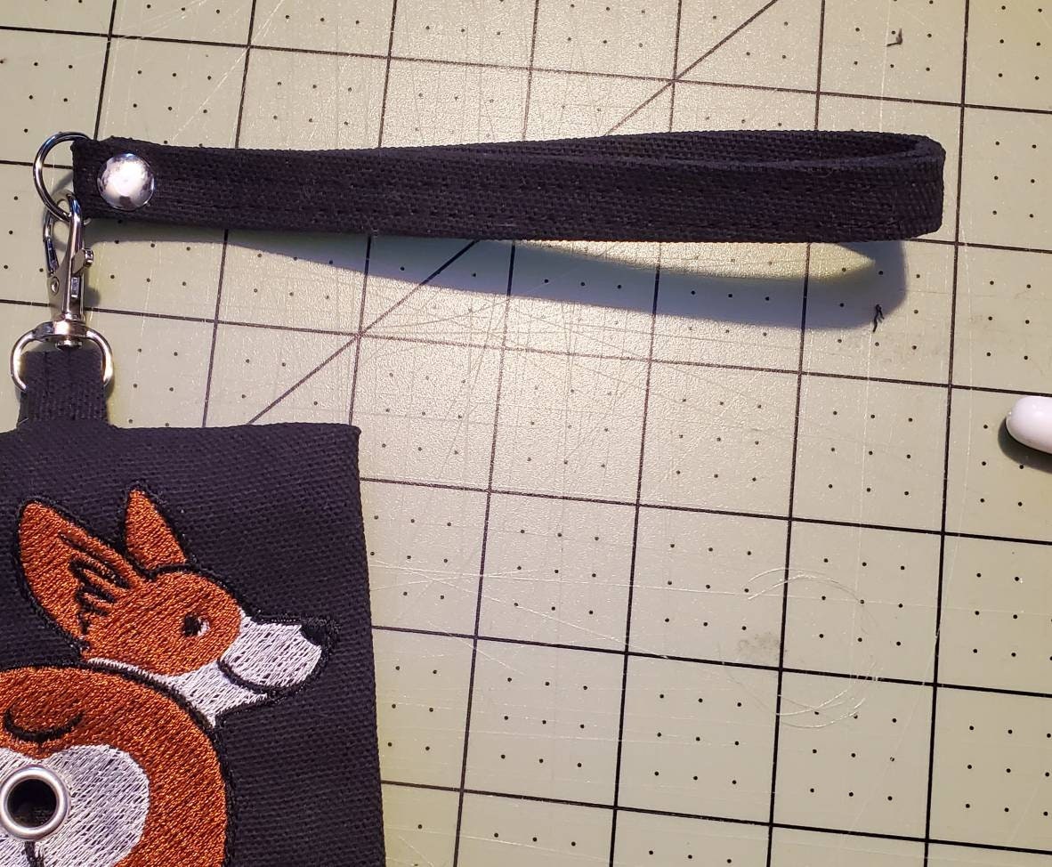 Add a black wrist strap to Cute Dog Butt bag dispenser zipper pouch
